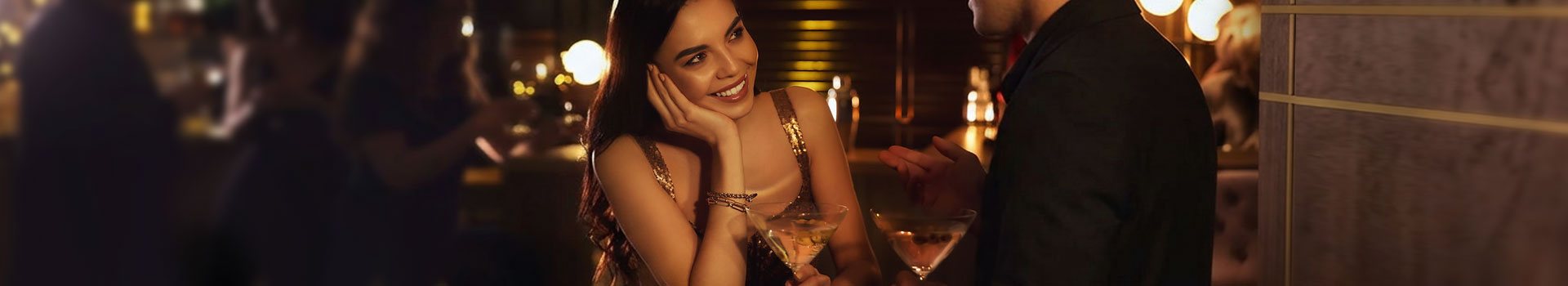 Glimlachende dame praat met een stijlvol geklede man aan de bar met cocktails door aantrekkingskracht