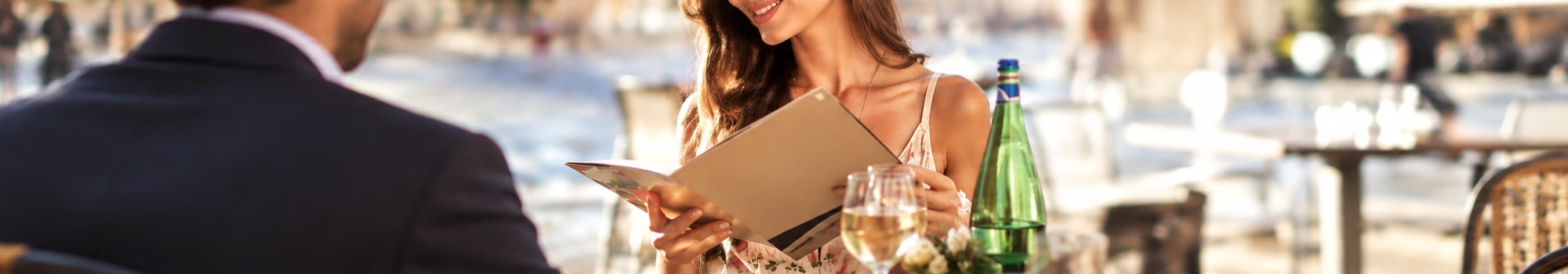 Koppel op terras met een glas wijn en menukaart tijdens een day out date