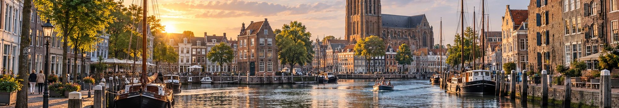 Historische haven van Dordrecht met Grote Kerk, gevels en boten aan het water